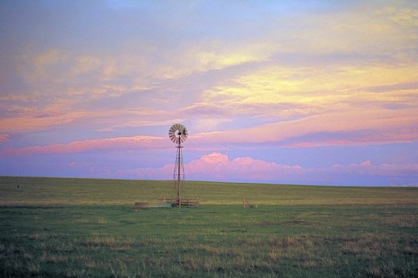 Sunset behind one of the still active windmills on the shortgrass steppe that provide water for livestock (1990s)
